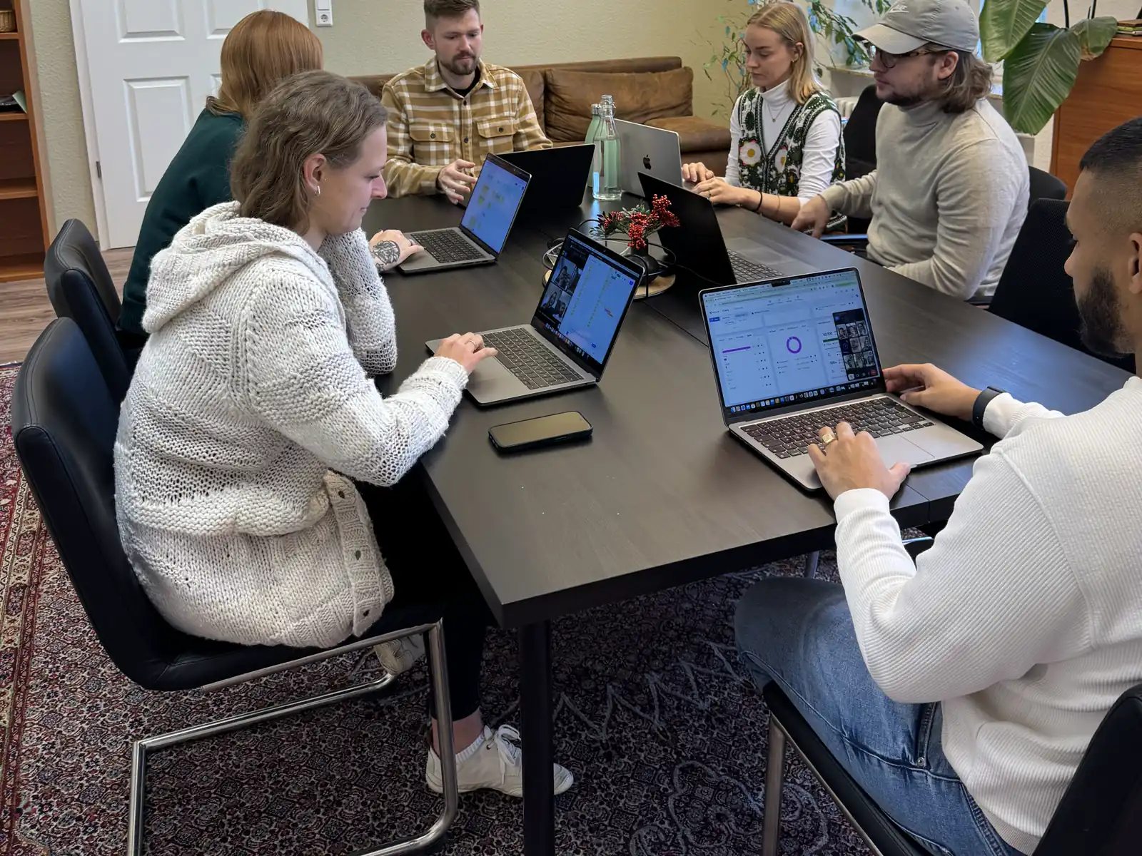 Das sorum-Team arbeitet gemeinsam an Laptops im Konferenzraum.