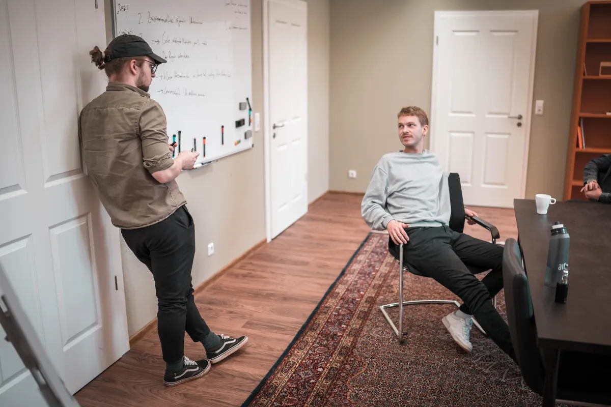 Zwei Kollegen besprechen sich am Whiteboard im sorum-Büro