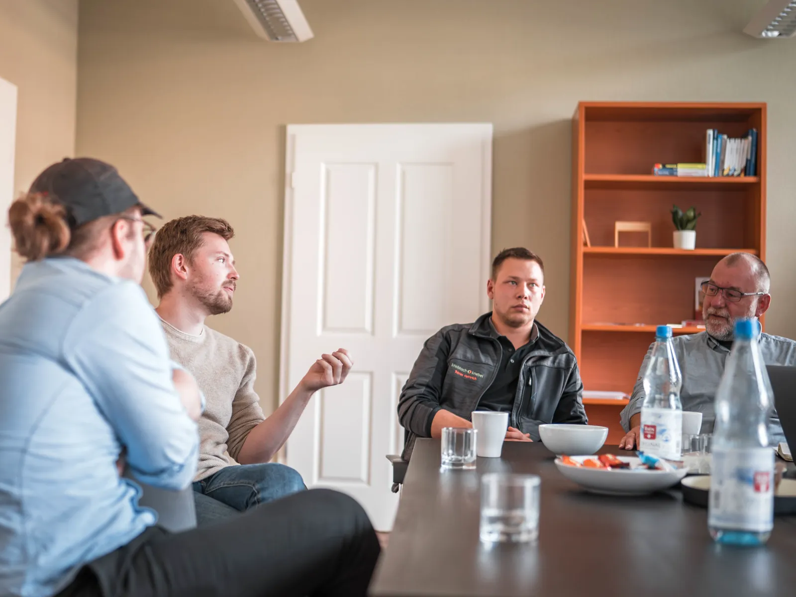 Workshop mit Kunden am Besprechungstisch im sorum-Büro: einer erklärt, die anderen hören aufmerksam zu